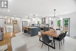 Open-concept kitchen with stone countertop island and dining room, ceramic tile - 