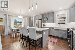 Spacious kitchen featuring wood-finish flooring and grey cabinetry - 
