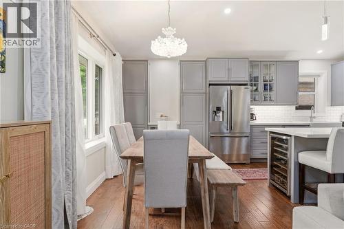 Open-concept kitchen featuring gray cabinetry, stainless steel appliances, a white subway tile backsplash, and a built-in wine refrigerator - 715 Drury Lane, Burlington, ON - Indoor