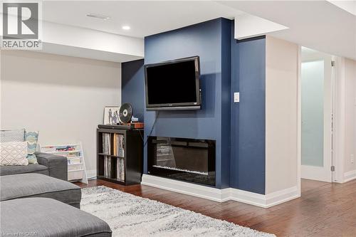 Media wall featuring a built-in electric fireplace, recessed lighting, and rich wood-finish flooring - 715 Drury Lane, Burlington, ON - Indoor