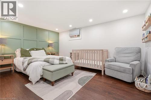 Spacious room featuring rich wood-finish flooring, recessed lighting, and a decorative paneled accent wall - 715 Drury Lane, Burlington, ON - Indoor Photo Showing Bedroom