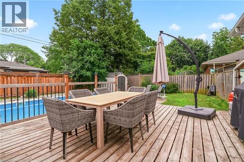 Spacious wood deck with an integrated swimming pool, surrounded by a wood privacy fence and mature trees - 715 Drury Lane, Burlington, ON - Outdoor With Deck Patio Veranda With Exterior