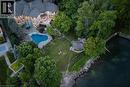 Stone exterior residence featuring multiple gabled rooflines - 4038 Lakeshore Road, Burlington, ON  - Outdoor With In Ground Pool With View 
