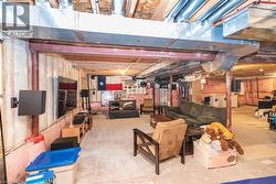 Unfinished basement featuring exposed ceiling joists, ductwork, and structural beams - 