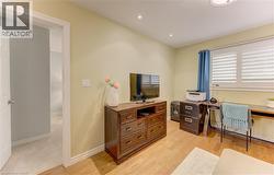 Room featuring wood-finish flooring, recessed lighting, and a window with white louvered shutters - 