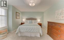 Carpeted room featuring a ceiling-mounted light fixture, a window with white louvered shutters, and light-toned walls - 