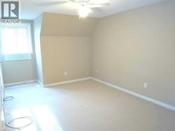 Carpeted room featuring a ceiling fan, a window with blinds, and neutral wall paint - 