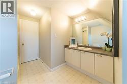 Bathroom vanity featuring an integrated sink, broad wall-mounted mirror, and overhead four-bulb light fixture - 