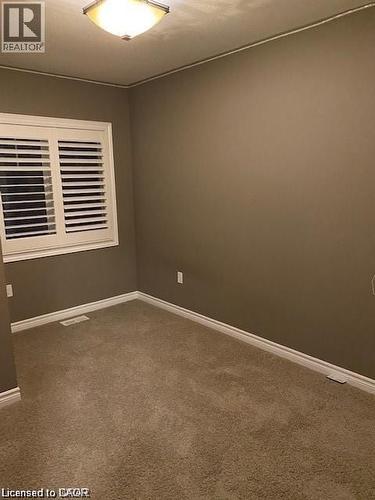 Carpeted room with neutral wall tones and white baseboards - 4 Isaiah Drive, Kitchener, ON - Indoor Photo Showing Other Room