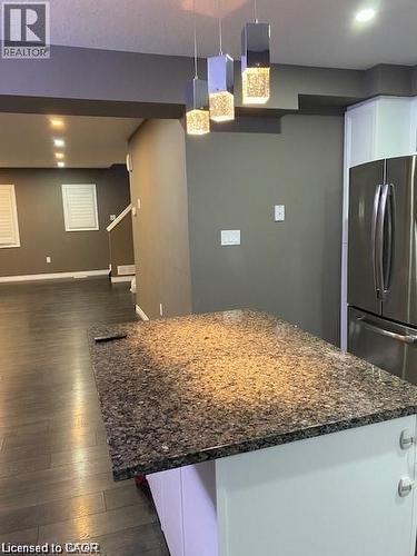 Kitchen island with a granite-style countertop and pendant lighting - 4 Isaiah Drive, Kitchener, ON - Indoor