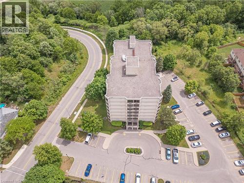 Multi-story building featuring an integrated parking lot, a circular driveway, and surrounding mature trees - 688 Preston Parkway Unit# 401, Cambridge, ON - Outdoor With View