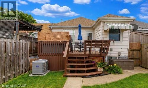 Rear exterior featuring a multi-level wood deck, privacy lattice, and a concrete patio - 237 Paling Avenue, Hamilton, ON - Outdoor With Deck Patio Veranda With Exterior
