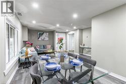 Open-concept living and dining area featuring recessed lighting, wood-finish flooring, and white trim - 