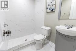 Modern bathroom featuring a walk-in shower with white marbled tile walls and a mosaic tile floor - 