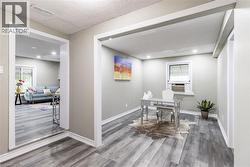 Open concept interior featuring light-toned walls and wood-finish flooring - 