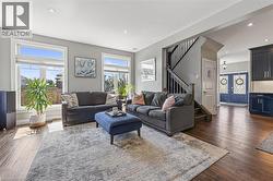 Spacious living area featuring large windows, recessed lighting, and wood-finish flooring - 