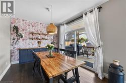 Dining area featuring dark wood-finish flooring and a floral accent wall - 