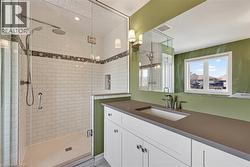 Spacious bathroom featuring a glass-enclosed shower with subway tile, mosaic accent band, and dual shower heads - 