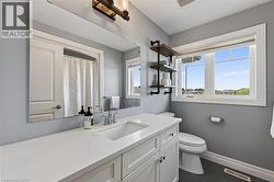Modern bathroom featuring a white vanity with integrated sink, a large mirror, and industrial-style shelving - 