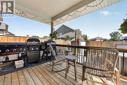 Expansive wood-finish deck featuring an overhead patio cover with string lighting - 