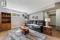 Living area featuring light gray walls, recessed lighting, and wood-finish flooring - 