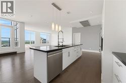 Contemporary kitchen island featuring a deep undermount sink, gooseneck faucet, and stainless steel dishwasher - 