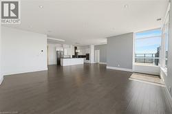 Spacious open-concept living area featuring wood-finish flooring and recessed lighting throughout - 