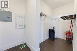 Utility closet featuring wood-finish flooring, white baseboards, and wire shelving - 