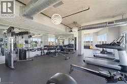 Fitness center with exposed ductwork, rubberized flooring, and large windows - 