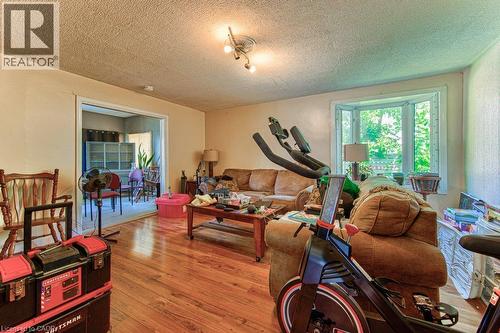 Spacious living area featuring wood-finish flooring, light-toned walls, and a multi-pane bay window - 819 Duke Street, Cambridge, ON - Indoor Photo Showing Living Room