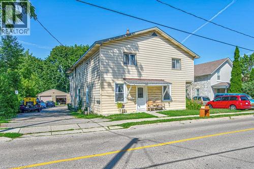 Two-story residence featuring light-colored siding, a covered front entry, and a paved driveway leading to a detached two-car garage - 819 Duke Street, Cambridge, ON - Outdoor
