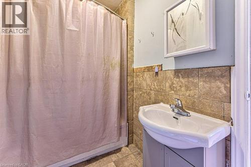 Pedestal sink with chrome faucet set against a tiled wall - 819 Duke Street, Cambridge, ON - Indoor Photo Showing Bathroom
