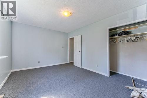Interior room featuring light blue painted walls, gray carpet flooring, white baseboards, and a built-in closet with a hanging rod - 819 Duke Street, Cambridge, ON - Indoor Photo Showing Other Room