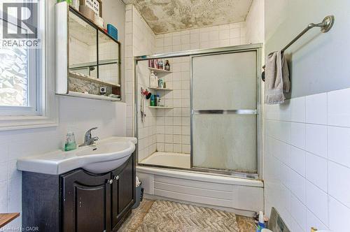 Bathroom featuring a white subway tile shower, sliding glass shower doors, and a vanity with an integrated sink - 819 Duke Street, Cambridge, ON - Indoor Photo Showing Bathroom