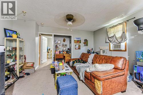 Carpeted interior space with light gray walls, a ceiling fan, and a window with an air conditioning unit - 819 Duke Street, Cambridge, ON - Indoor