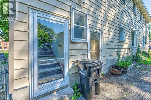 Side entrance featuring a storm door, concrete steps, and horizontal siding - 819 Duke Street, Cambridge, ON - Outdoor