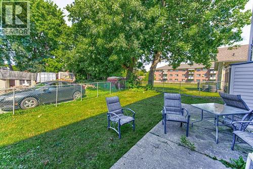 Concrete patio area with a chain-link fence and mature trees - 819 Duke Street, Cambridge, ON - Outdoor