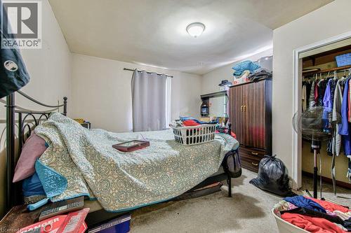 Carpeted room featuring a window with curtain rod, a ceiling-mounted light fixture, and a built-in closet with hanging rod and shelving - 819 Duke Street, Cambridge, ON - Indoor Photo Showing Bedroom