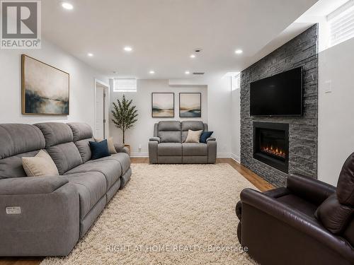 Finished Lower Level (Virtually Staged) - 2042 Quinte Street, Burlington, ON - Indoor Photo Showing Living Room With Fireplace
