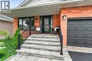 Brick exterior featuring a covered front entry with stone steps, black railings, and a decorative glass door - 30 Carriagegate Drive, Hamilton, ON  - Outdoor With Deck Patio Veranda 