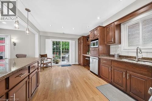 Kitchen featuring wood-finish flooring, recessed lighting, and rich wood cabinetry - 30 Carriagegate Drive, Hamilton, ON - Indoor Photo Showing Kitchen With Double Sink