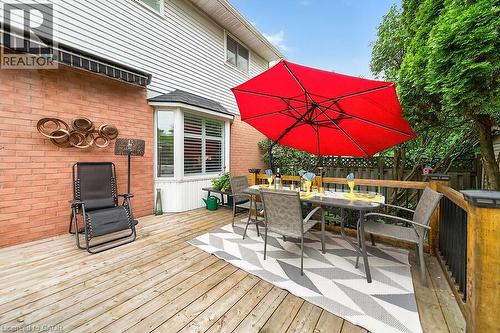 Wood-finish deck featuring a bay window, brick and siding exterior, privacy fencing, and mature perimeter trees - 30 Carriagegate Drive, Hamilton, ON - Outdoor With Deck Patio Veranda With Exterior