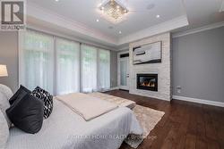 Bedroom featuring fireplace and wall of windows - 