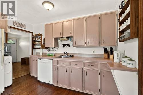 Kitchen featuring wood-finish flooring, ample cabinetry, integrated sink, and white appliances - 958 Highland Road E, Hamilton, ON 