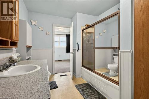 Bathroom with a single basin vanity featuring a speckled countertop and chrome faucet - 958 Highland Road E, Hamilton, ON 