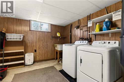 Dedicated utility area featuring a window, built-in shelving, a utility sink, and wood-panel accent walls - 958 Highland Road E, Hamilton, ON 