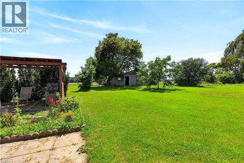 Expansive green lawn with mature trees and a rustic shed - 958 Highland Road E, Hamilton, ON 