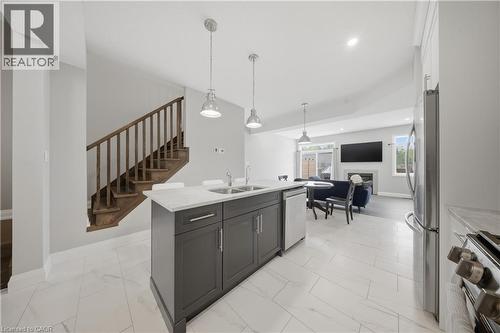 Open-concept main level featuring a kitchen island with dual sinks, pendant lighting, and stainless steel appliances - 107 Stephenson Way, Palmerston, ON - Indoor Photo Showing Kitchen With Double Sink
