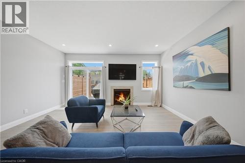 Living area featuring a fireplace with stone surround, recessed lighting, and light wood-finish flooring - 107 Stephenson Way, Palmerston, ON - Indoor Photo Showing Living Room With Fireplace