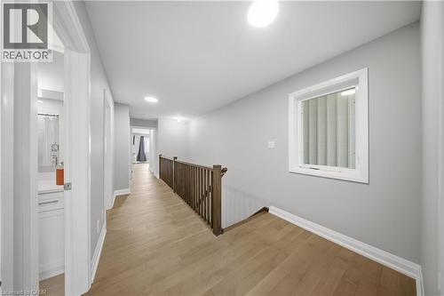 Upper-level hallway featuring wood-finish flooring, light gray wall paint, white trim, and a wood railing - 107 Stephenson Way, Palmerston, ON - Indoor Photo Showing Other Room